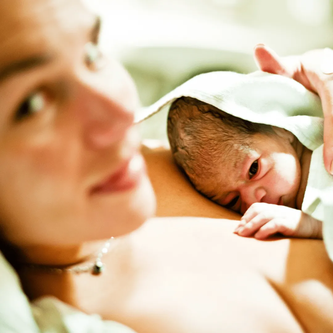 A mother holding her newborn baby, illustrating newborn care.